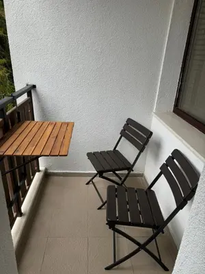 two chairs and a wooden table on a balcony at Borovets Gardens Chill Hill Studio by Joro in Borovets