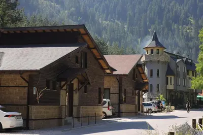 a large wooden building with a tower on a street at Horlog Castle in Trigrad