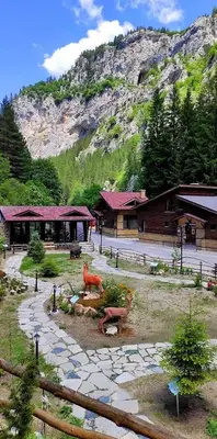 a resort with a building with a mountain in the background at Horlog Castle in Trigrad