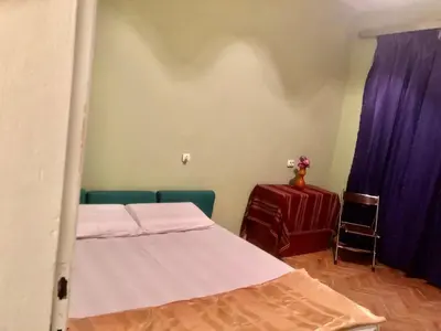 a room with two beds and a table with purple curtains at City Flat Riverside Maritza in Plovdiv