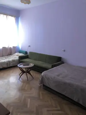 a living room with a green couch and a table at City Flat Riverside Maritza in Plovdiv