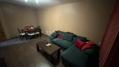 a living room with a green couch and a table at Astoriq in Sofia