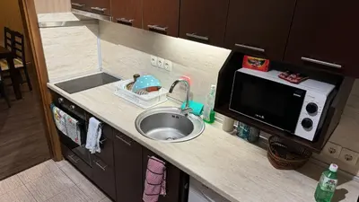 a kitchen counter with a sink and a microwave at Astoriq in Sofia
