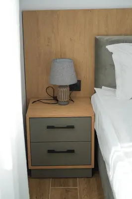 a nightstand with a lamp on it next to a bed at Sun City Apartment in Sandanski
