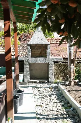 a stone fireplace in the middle of a yard at Sun City Apartment in Sandanski