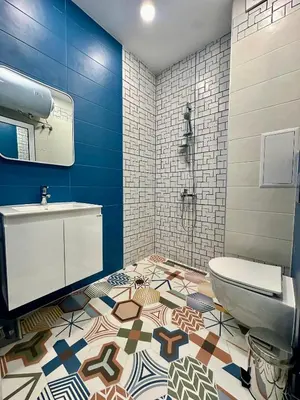 a bathroom with a toilet and a sink on a mosaic floor at Noble House Comfort Place in Sofia