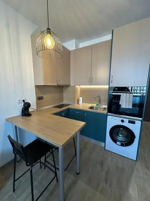 a kitchen with a wooden table and a washer and dryer at Noble House Comfort Place in Sofia