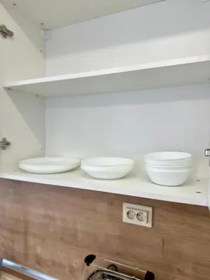 a kitchen counter with white bowls on a shelf at Central District 3 Bedroom Place in Plovdiv