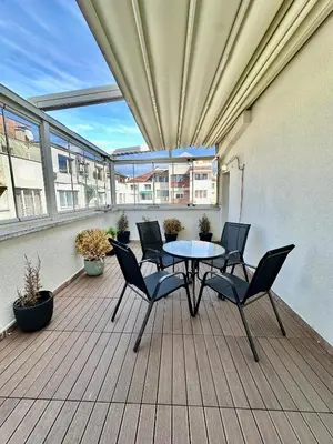 a patio with a table and chairs on a balcony at Central District 3 Bedroom Place in Plovdiv