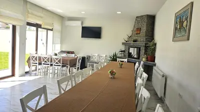 a dining room with a table and chairs and a fireplace at Самуил къща за гости in Ognyanovo