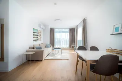 a white living room with a table and a couch at My Campus 1 bdrm, Mountain view, Free parking, Self check-in in Sofia