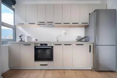 a kitchen with white cabinets and a refrigerator at My Campus 1 bdrm, Mountain view, Free parking, Self check-in in Sofia