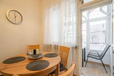 a dining room with a table and a clock on the wall at Modern and Calm 2BDRM Apt in City Centre in Sofia
