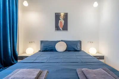 a bedroom with a blue bed with two lamps at Modern and Calm 2BDRM Apt in City Centre in Sofia