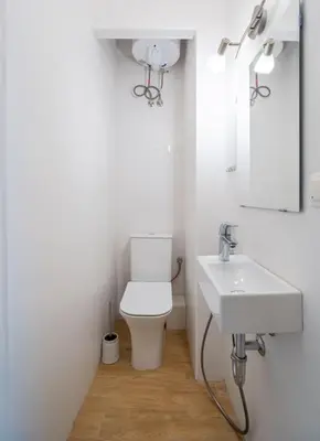a white bathroom with a toilet and a sink at Modern and Calm 2BDRM Apt in City Centre in Sofia
