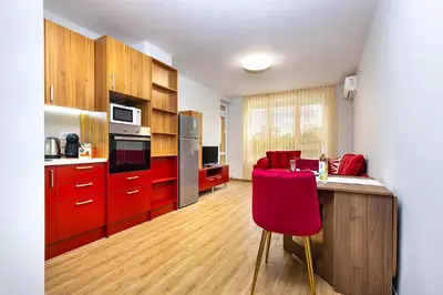 a kitchen with red cabinets and a red chair at Bright and Cozy Apartment Next to a City Park by Flat Mаnager in Plovdiv
