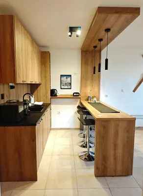 a kitchen with wooden cabinets and a counter top at Friendly apartment -top location in Bansko
