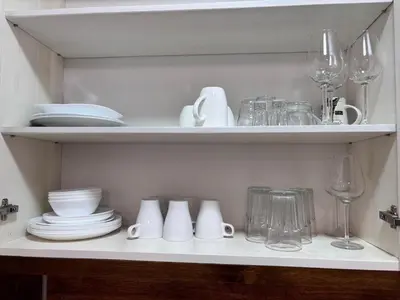 a shelf with dishes and glasses and wine glasses at Belvedere Holiday Club H80 in Bansko