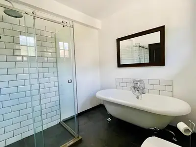 a bathroom with a tub and a glass shower at Large Cosy House by a Forest - Treehouse, BBQ, Fireplace & Mountain in Sopot
