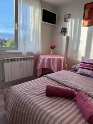 a bedroom with two beds and a table with a vase of flowers at Central Art Studio in Sofia
