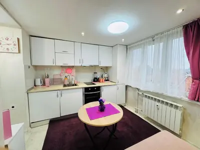 a small kitchen with white cabinets and a purple table at Central Art Studio in Sofia