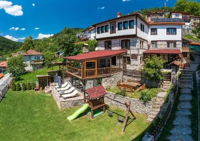 a large house on a hill with a playground at Valkanovi House in Pamporovo
