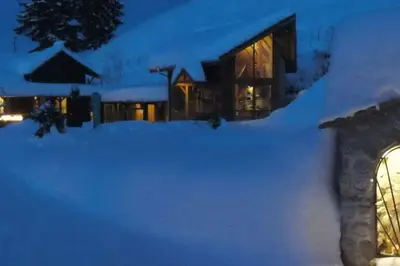a house covered in snow at night at Ski liviomoritz at gma il com Chalet in Madzhare