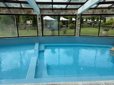 a large swimming pool in a house with windows at Мия4 Спа хотел Свети Спас in Velingrad