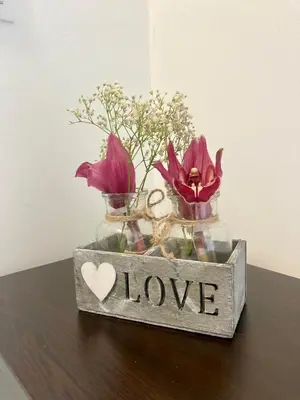 a vase with flowers and a sign that says love at Апартамент Пирин in Sandanski