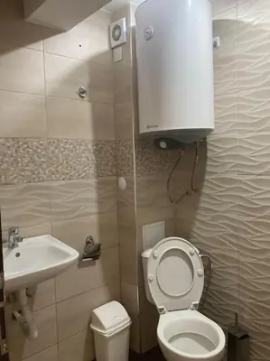 a small bathroom with a toilet and a sink at Апартамент Пирин in Sandanski