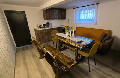 a living room with a table and chairs and a kitchen at Къща за гости Етерна - Guest house Eterna in Starosel