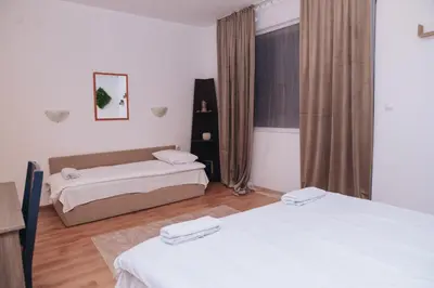 a bedroom with two beds and a window at BASSO Guest Rooms in Perushtitsa