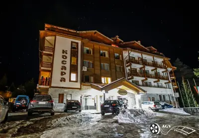 a large building with cars parked in front of it at Ski In Out Aparthotel Kosara in Bansko