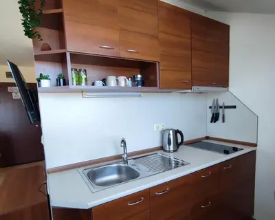 a small kitchen with a sink and wooden cabinets at 