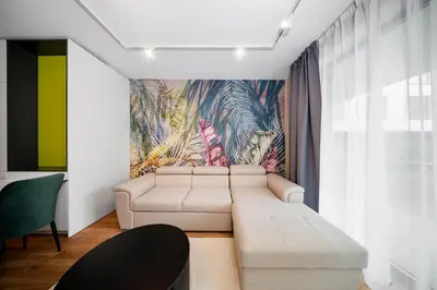 a living room with a couch and a painting on the wall at Aviva Living by Flat Mаnager in Sofia