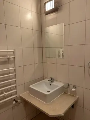 a white bathroom with a sink and a mirror at Cozy Mountain Apartment in Bansko