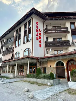 a large white building with a red sign on it at Cozy Mountain Apartment in Bansko