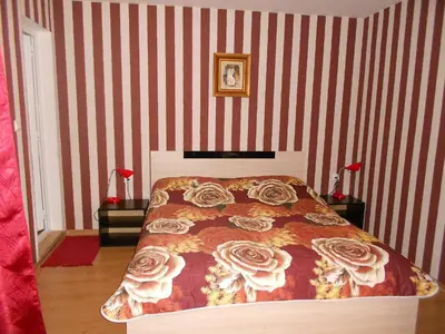 a bedroom with a bed and red and white stripes at Guest House Tsenovi in Koprivshtitsa