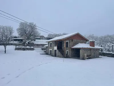 a building with snow on the ground next to a road at Casa Lavandula in Sredno Gradishte