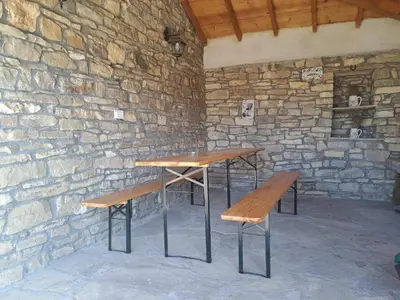 two wooden tables and benches in a stone wall at Casa Lavandula in Sredno Gradishte