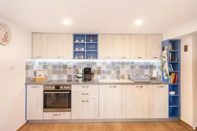 a kitchen with wooden cabinets and blue and white tiles at Casa Lavandula in Sredno Gradishte