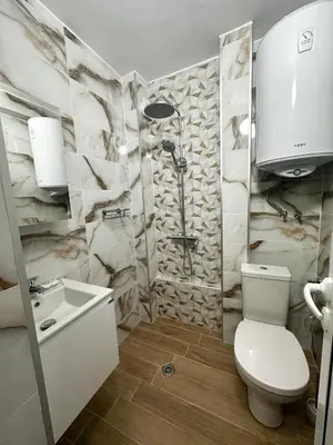 a bathroom with a toilet and a sink and a shower at Bibi Central Apartment Plovdiv in Plovdiv