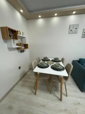 a white dining room with a table and chairs at Apartment Iztochen blvd, free parking in Plovdiv