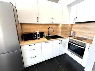 a kitchen with white cabinets and a sink and a refrigerator at AveNew Luxury Apartment 2 in Sofia