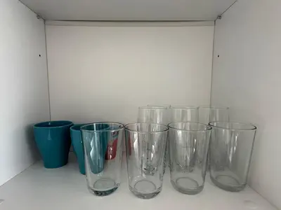 four empty glass cups sitting on a shelf at 1BD Flat near Maritsa river and City Center in Plovdiv