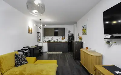 a living room with a yellow couch and a kitchen at Cozy 1BD Flat Close to the City Center by Flat Mаnager in Sofia