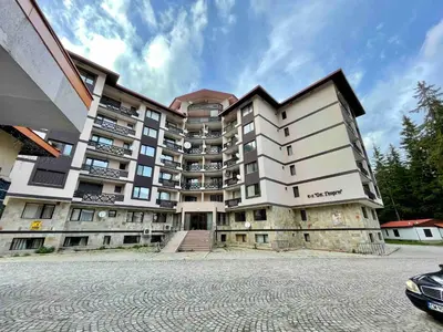 a large apartment building in front of a parking lot at Комплекс Свети Георги in Pamporovo