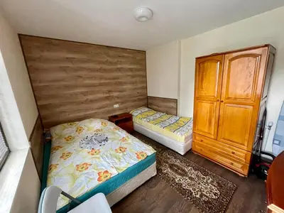 a bedroom with two beds and a wooden cabinet at St Georgi in Pamporovo