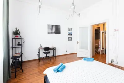 a bedroom with a bed with blue slippers on it at Escape in photos in top centre apartment in Sofia