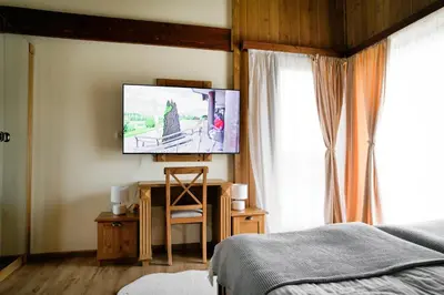 a bedroom with a bed and a tv on a wall at Pirin Golf Villa Relax in Razlog